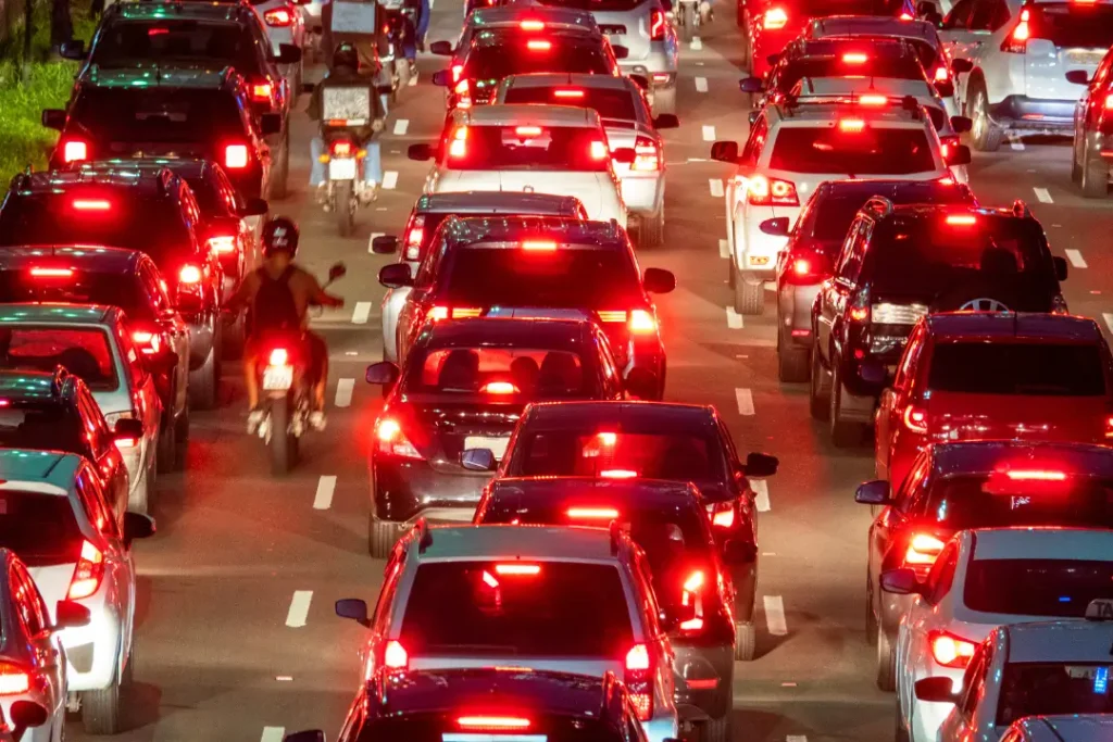 Nos semáforos das grandes cidades, criatividade e persistência viram fonte de renda para quem transforma segundos em oportunidade | Foto: Reprodução/Canva

farol